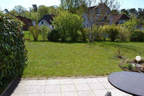 a yard with a grassy yard with a table at Fewo Möwenweg 8 - Damme GM 69180 in Graal-Müritz