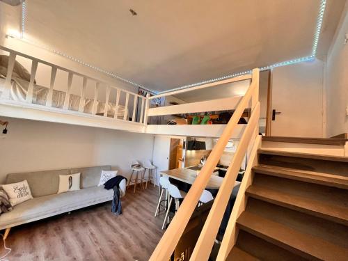 Cette chambre dispose d'un escalier, d'un canapé et d'une table. dans l'établissement Appartement cosy à 100 m de la plage ac vue sur mer, à Valras-Plage
