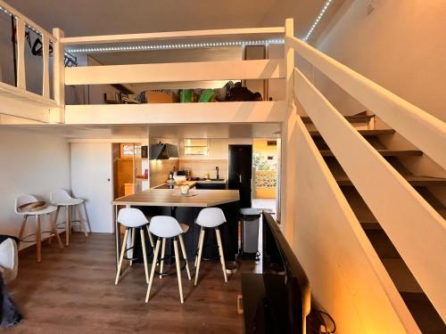 d'une cuisine et d'une salle à manger avec une table et des tabourets. dans l'établissement Appartement cosy à 100 m de la plage ac vue sur mer, à Valras-Plage