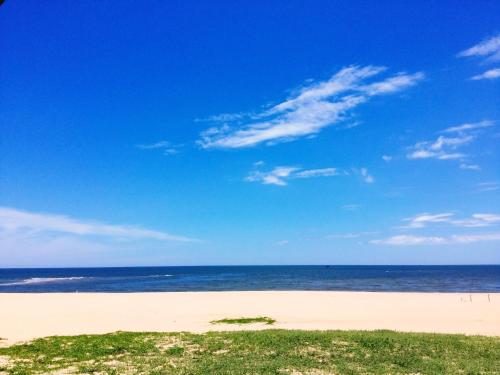 a beach with a blue sky and the ocean at Amazing Hotel, Trương Pháp, Quang Phú, Đồng Hới in Dong Hoi