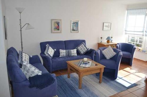 a living room with blue couches and a coffee table at FeWo Möwennest Felstehausen GM 69252 in Graal-Müritz