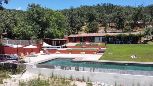 Un complejo con piscina y un edificio. en El Escondite De Pedro Malillo, en Candeleda