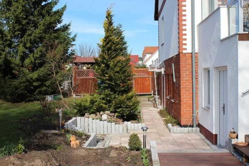 un giardino con una pineta e una recinzione di Ruhige FEWO im Erdgeschoß Labahn GM 69504 a Graal-Müritz