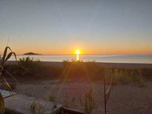 una puesta de sol en una playa con la puesta de sol sobre el océano en Da Fra e La, en Girasole
