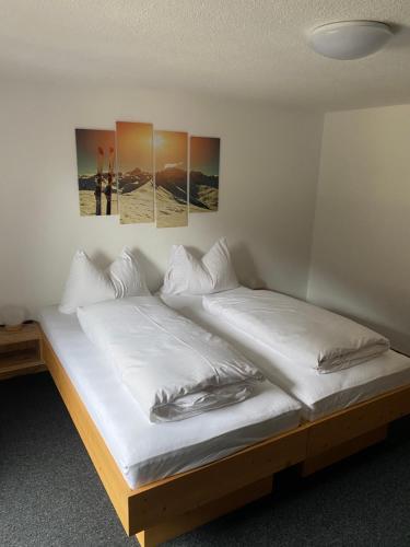 a bed in a room with two posters on the wall at Appartement Walter Mall in Sankt Anton am Arlberg