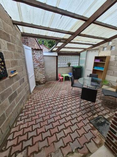 d'une terrasse avec un toit et une table et des chaises. dans l'établissement L Auberge du mont des bruyeres PLAIN PIED, à Saint-Amand-les-Eaux