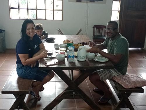 mężczyzna i kobieta siedzący przy stole w obiekcie Gran Camping Cabanas da Fazenda w mieście Visconde De Maua