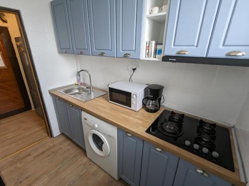 a kitchen with a counter top with a microwave and a sink at Old town apartment in Bucharest