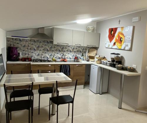 a kitchen with a table and some chairs in it at Vista al Tramonto B&B in Falerna