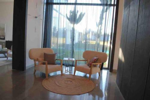 a living room with chairs and a table and a window at Wonderful villa near to the beach in Casablanca
