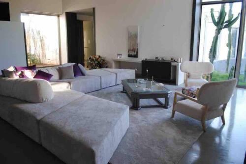 a living room with a couch and a table and chairs at Wonderful villa near to the beach in Casablanca