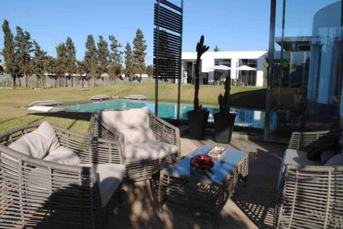 une terrasse avec une table, des chaises et une piscine dans l'établissement Wonderful villa near to the beach, à Casablanca