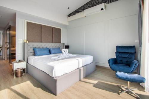 a bedroom with a bed and a blue chair at 【Beach Front】海景沙滩别墅，私人泳池，免费早餐，女佣每日清洁，生活方便交通便利 B in Phuket Town