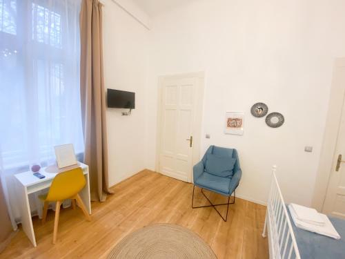 een woonkamer met een bureau en een blauwe stoel bij Perfect Stay in Cluj-Napoca
