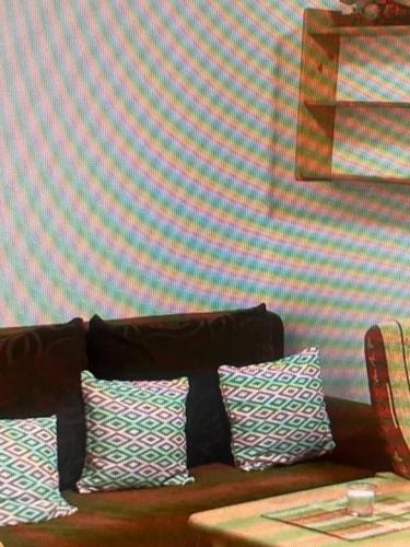 a couch with three pillows against a striped wall at Mountain Deluxe in Ružomberok