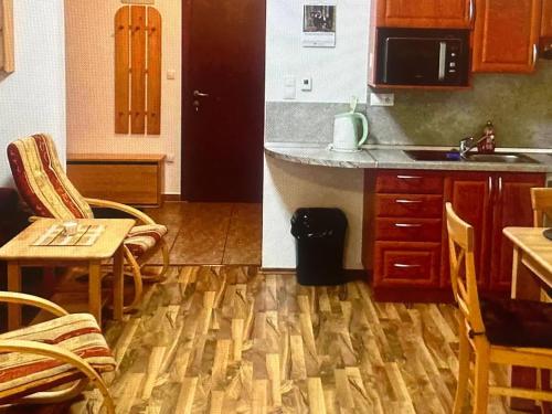 a kitchen with a wooden floor and a table and chairs at Mountain Deluxe in Ružomberok