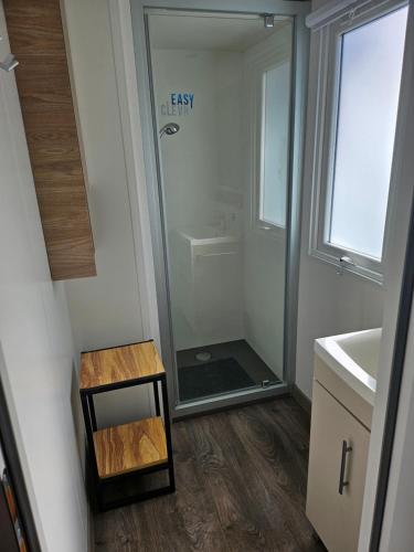 La salle de bains est pourvue d'une douche, d'un lavabo et d'un miroir. dans l'établissement Mobil home 6 personnes, à Saint-Brévin-les-Pins