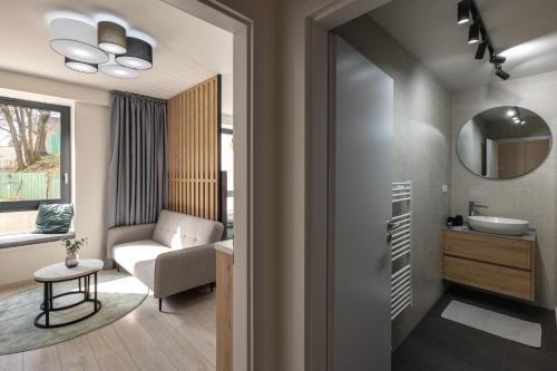 La salle de bains est pourvue d'un lavabo, d'une chaise et d'un miroir. dans l'établissement Apartment EDIAS, à Banská Bystrica