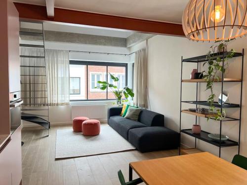 a living room with a couch and a table at Unique design triplex with rooftop terrace in Mechelen
