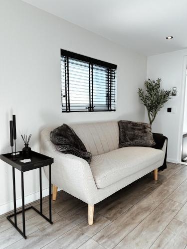 un sofá blanco en una sala de estar con mesa en Vakantiehuisje Noé, en Gorinchem