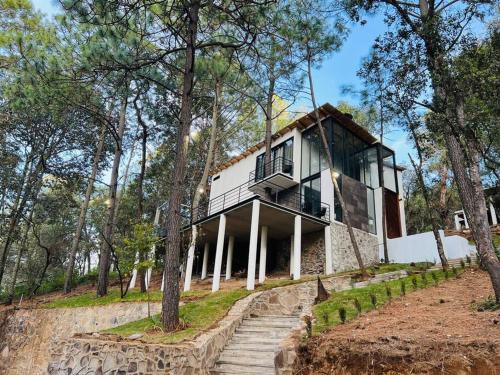 een huis bovenop een heuvel met bomen bij Cabaña Veinte 21 in Mazamitla