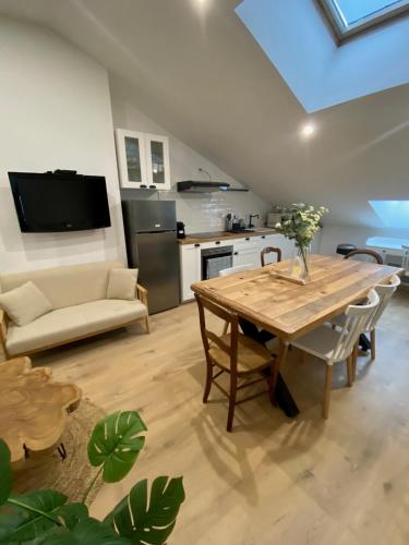 Il comprend un salon avec une table en bois et une cuisine. dans l'établissement Le LOFT du CENTRE HISTORIQUE, à Périgueux