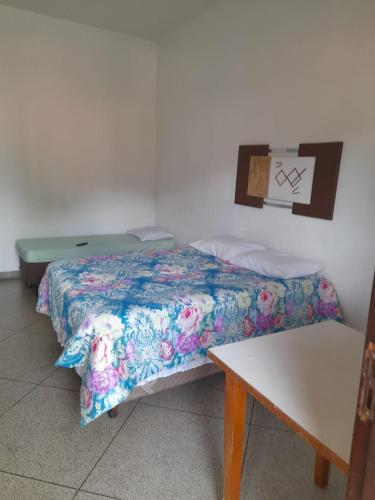 a room with two beds and a table and a desk at HOTEL GUARAREMA in Guararema