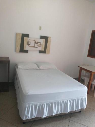 a white bed in a room with at HOTEL GUARAREMA in Guararema