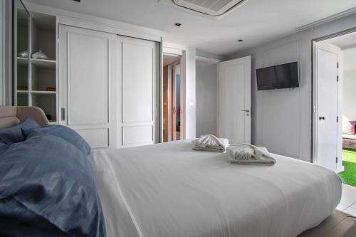 a bedroom with a bed with two towels on it at 【Beach Front】海景沙滩别墅，私人泳池，免费早餐，女佣每日清洁，生活方便交通便利 B in Phuket Town
