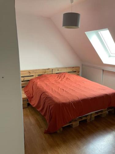une chambre avec un lit avec une couverture rouge dans l'établissement Appart 8min à pied de la gare, au Mans