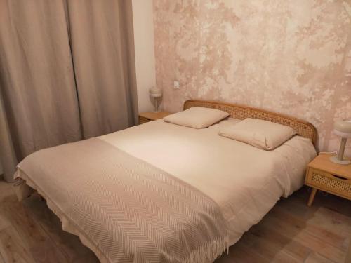 une chambre avec un lit avec deux oreillers dessus dans l'établissement ô détour des vignes, à Cavignac