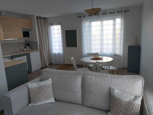 Il comprend un salon avec un canapé, une cuisine et une table. dans l'établissement ô détour des vignes, à Cavignac