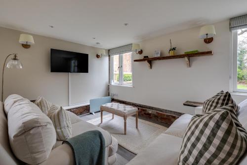 a living room with a white couch and a tv at Oak Tree Hideaway in Whitchurch