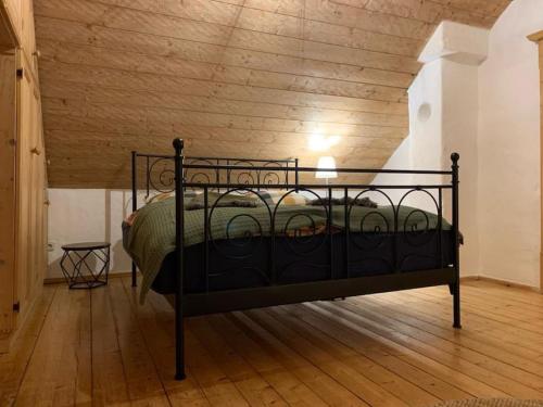 een zwart bed in een kamer met een houten plafond bij Ferienhaus // Waldlerhaus - Bayern - Bayerischer Wald in Windberg