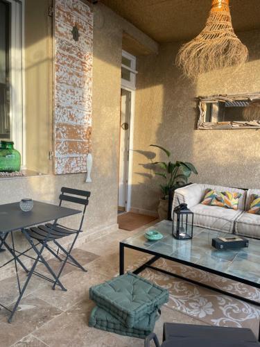 een woonkamer met een bank en een tafel bij Appartement en bord de mer in Fos-sur-Mer