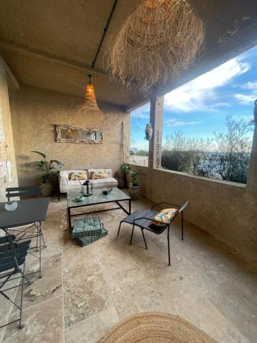 een woonkamer met een bank en een tafel bij Appartement en bord de mer in Fos-sur-Mer