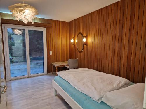 1 dormitorio con cama, mesa y ventana en CozyWisi holiday home for 1 to 6 people near Technorama 4 bedrooms 2 bathrooms bookable from 2 days, en Wiesendangen