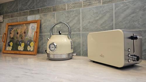 a toaster and a toaster on a counter next to a painting at Rinio House in Adamas in Mytakas