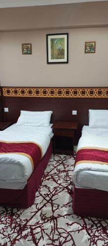 a hotel room with two beds in a room at فندق لؤلؤة نور توصيل مجاني للحرم 24 ساعة in Az Zāhir