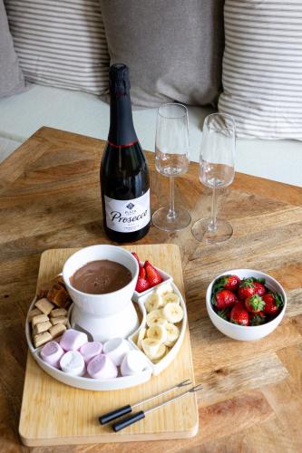 a table with a bottle of wine and a tray of food at Oak Tree Hideaway in Whitchurch