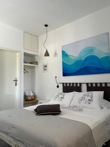 um quarto com uma cama com um quadro na parede em Rodi Apartments em Parikia