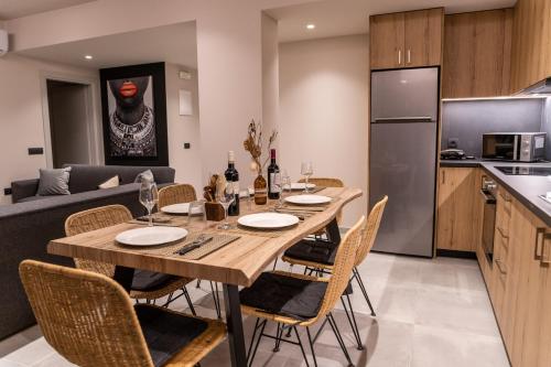 a kitchen and dining room with a wooden table and chairs at Grand House - Private Outdoor Jacuzzi - Sleeps 6 in Hersonissos