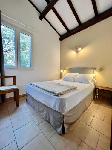 a bedroom with a large bed in a room with windows at Résidence Padovani Marina in Calcatoggio