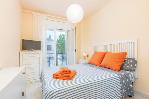 1 dormitorio con 1 cama con toallas de color naranja en TRA9-CASA con BARBACOA, PISCINA comunitaria en verano, 5 min en coche del MAR y el CENTRO, en Empuriabrava