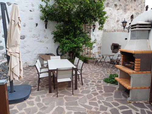 a patio with a table and chairs and a fireplace at Casa la plaza in Agulo