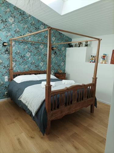 1 dormitorio con cama con dosel y paredes azules en Le clos du prieuré, en Montjean-sur-Loire