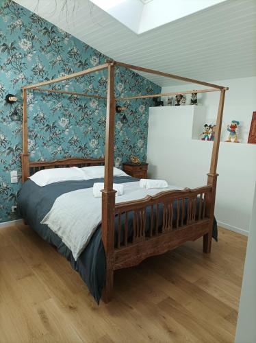 - une chambre avec un lit à baldaquin et des murs bleus dans l'établissement Le clos du prieuré, à Montjean-sur-Loire