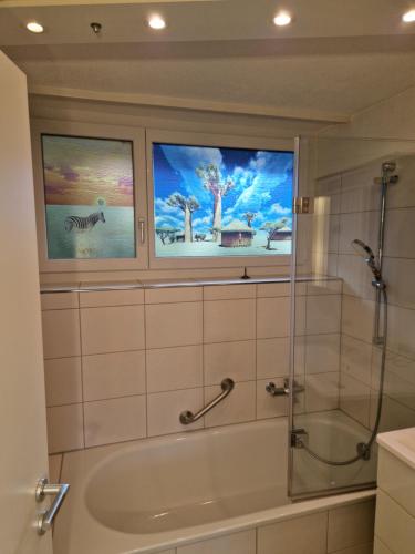 two windows in a bathroom with a bath tub at CozyWisi holiday home for 1 to 6 people near Technorama 4 bedrooms 2 bathrooms bookable from 2 days in Wiesendangen