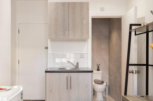 a bathroom with a sink and a toilet at Modern Cosy Haven For Travelers in Hanwell