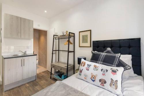 a small bedroom with a bed and a kitchen at Modern Cosy Haven For Travelers in Hanwell